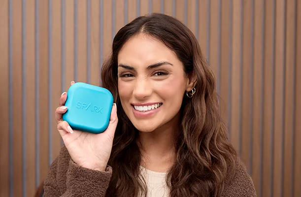 A woman holding a spark aligners case