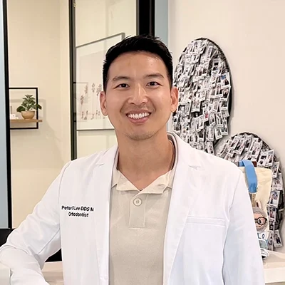 Orthodontist Peter Lee Leaning On Desk